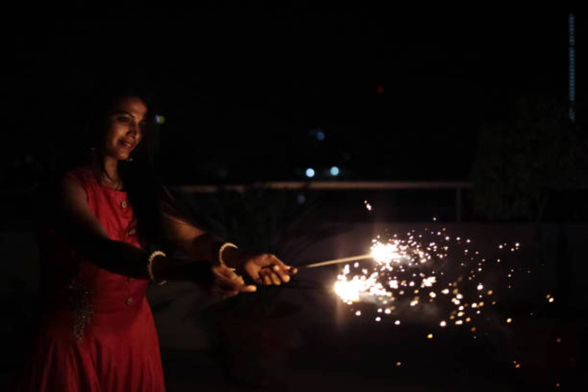 Two Bangladeshi young girl hold oil lamps as they poses for a photo during  the Diwali festival at a temple in Dhaka. The Diwali festival of lights  symbolizes the victory of good